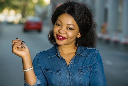 Cheerful girl wearing blue jeans shirt pointing a place with hand in the street