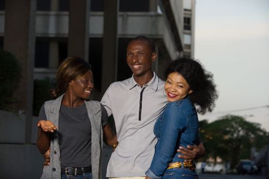 Group of young people walking on the street. three friends having fun and talking outdoors