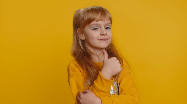 Great job, nice work. Young preteen child girl kid showing thumbs up and nodding in approval, successful good work, celebrate win, clapping hands. Little toddler children isolated on yellow background