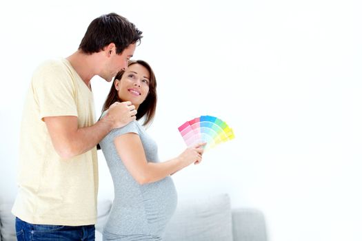 I pick that one honey - Copyspace. Pretty young pregnant woman picking a colour for their babies room and showing her husband - Copyspace
