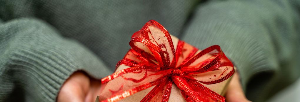 Female hands hold a craft gift box. Christmas, birthday concept. banner