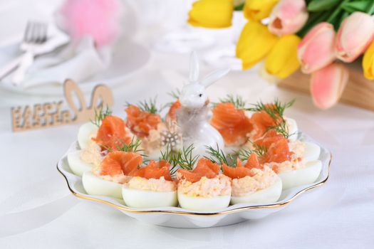 Appetizer of eggs stuffed salmon pate and yolks with salmon slices. Idea Easter table 