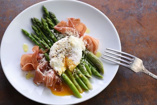 Eggs Benedict with parmesan, green asparagus and Parma ham