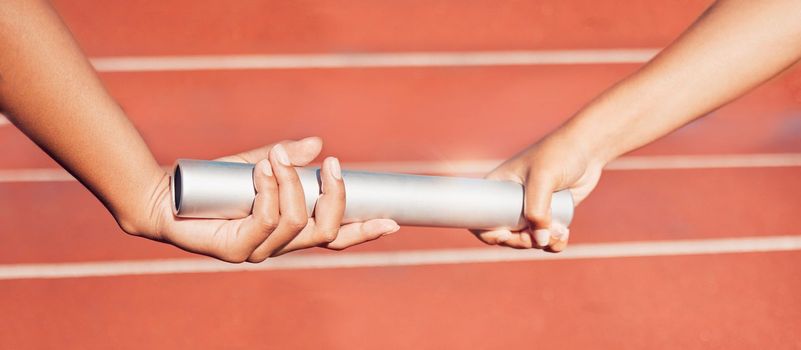 Hands, baton and relay with a sports woman and partner running a race with teamwork on a track. Fitness, health and exercise with a female athlete team racing in an athletics arena for competition.