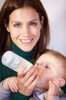 She knows whats best for him - Infant nutrition. Pretty young mother bottle-feeding her infant son