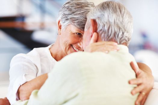 Romance at home. Smiling mature woman and man looking at each other while spending romantic time