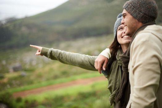 This view is stunning. A young couple admiring the view while out hiking during winter