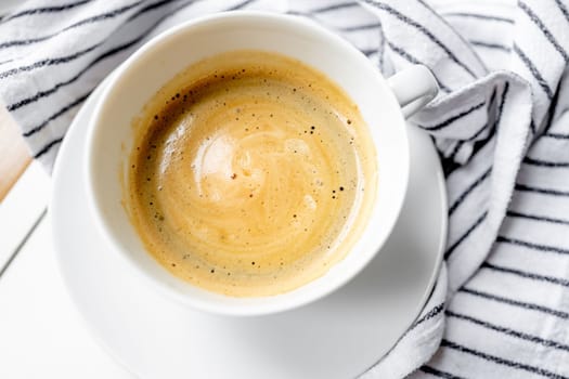 Cup of aromatic coffee on the table in the kitchen