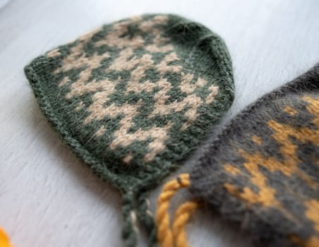 knitted newborn baby clothes composed on a wood table