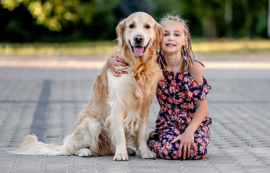 Preteen girl and her golden retriever dog on lace looking at camera. Female child kid with a purebred labrador doggy pet