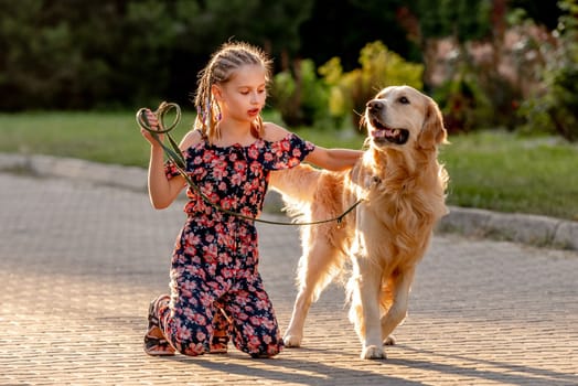 Preteen girl and her golden retriever dog on lace looking at camera. Female child kid with a purebred labrador doggy pet