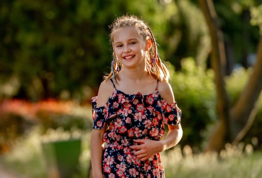 Little girl smiling in sunny spring day outdoors portrait. Cute child kid at nature