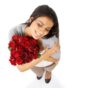 Shes so in love. A beautiful woman holding a bouquet of roses isolated on a white background