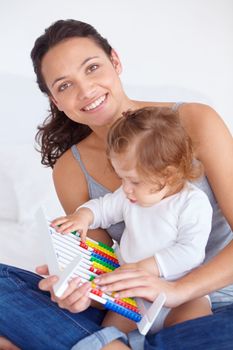 Helping her daughter learn. A mother showing her baby daughter how an abacus works