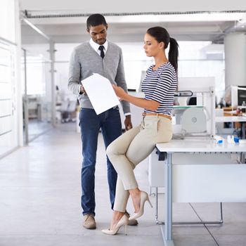 Always the last in the office. A shot of two colleagues discussing paperwork while standing in an office