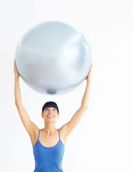 Holding up great health ideals. Healthy young woman exercising while holding an exercise ball