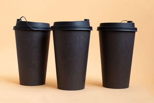 Set of three takeaway black coffee cup on neutral background. Mock -up, nobody, front view