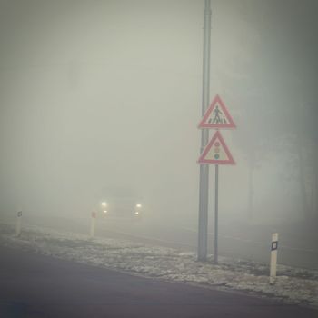 Cars in the fog. Traffic on the road in winter in bad weather. Dangers of driving cars.