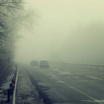 Cars in the fog. Traffic on the road in winter in bad weather. Dangers of driving cars.