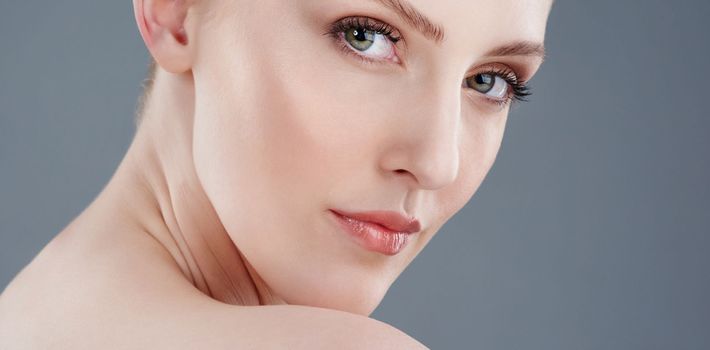 Beauty that turns heads. Studio portrait of a young woman with beautiful skin isolated on gray