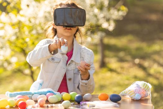 Teen gamer girl experiences fantasy world wearing virtual reality glasses with headphones. teenage girl with easter egg in virtual glasses