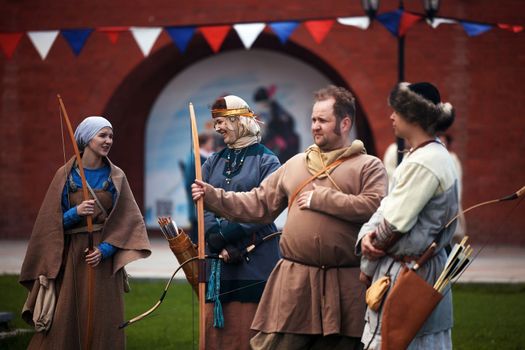 Medieval archery tournament. Archers before the tournament in the medieval castle yard. Peoples in medieval dress with a wooden bows. historical reconstruction. 14.05,2022. Yoshkar-Ola, Russia