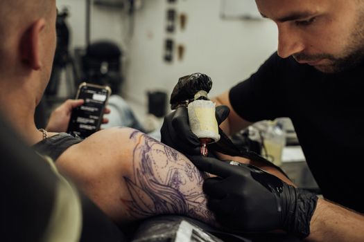 Male Tattoo Artist Draws on Clients Skin, Process of Creating Tattoo Art