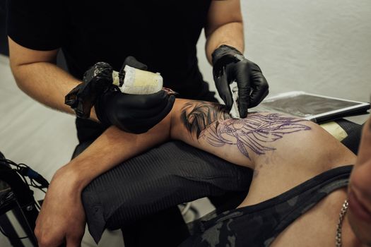 Male Tattoo Artist Draws on Clients Skin, Creating Tattoo process