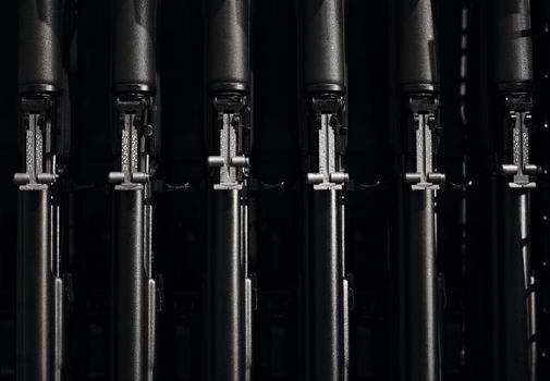 Stocks of weapons. New automatic rifles in a box. The sighting bar of an automatic rifle. Production and sale of arms. Weapon in a box on a black background. Weapon Theme.