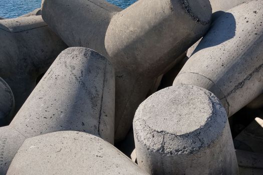 Close-up on the concrete structure Tetrapods. Concrete for hydraulic structures. Concrete breakwaters on the beach