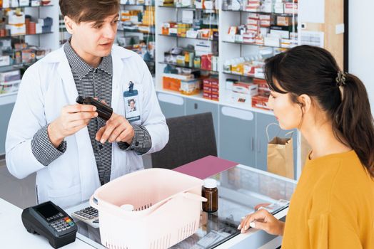 Professional pharmacist advise or explain property of qualified medical product to customer in pharmacy, druggist answer to client healthcare inquiry, medical service and consultation concept.