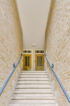 some stairs leading up to a building with shutters on each side and yellow doors in the other way behind