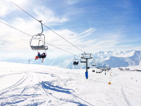 Lift at ski resort. People take elevator up hill. Ski sport. Funicular lifts people. Sunny winter day. Gudauri Georgia, mountain slope