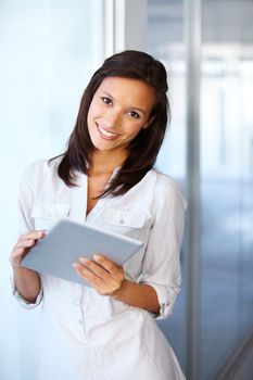 Tablet technology in the workplace. A beautiful businesswoman holding a digital tablet