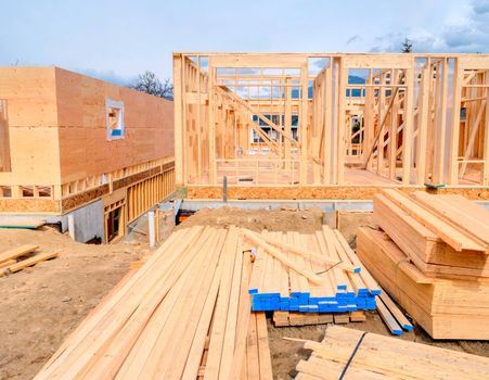 Wooden frame of new building with engineered lumber materials prepared for the construction. Two by four lumber wood
