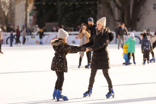 Mother and daughter skateing on ice