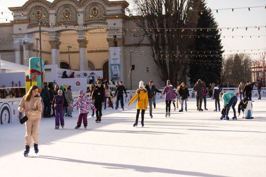 KYIV, UKRAINE - 2 January, 2023: Ice-skating people. People have fun in ice arena at the city ice rink. New Years holidays in city Kyiv