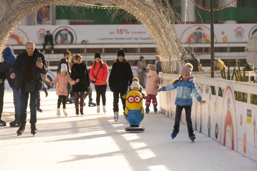 KYIV, UKRAINE - 2 January, 2023: Ice-skating people. People have fun in ice arena at the city ice rink. New Years holidays in city Kyiv