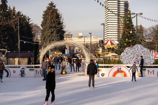 KYIV, UKRAINE - 2 January, 2023: Ice-skating people. People have fun in ice arena at the city ice rink. New Years holidays in city Kyiv