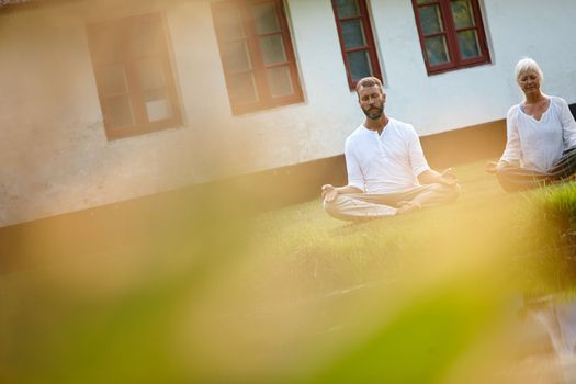 Complete tranquility. a mature couple meditating in the outdoors