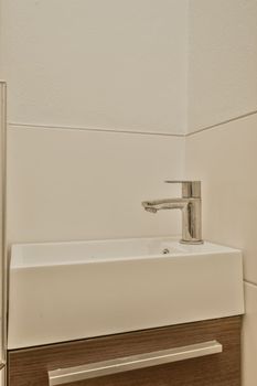 a white sink in a bathroom with wood paneling on the wall behind it is a mirror and light fixture