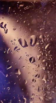 Macrophotography.Water drops on the glass surface of a glass with a blue-brown backlight.Texture or background