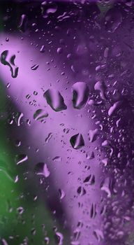Macrophotography.Drops of water on the glass surface of a glass with blue-violet illumination.Texture or background
