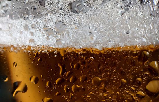 Drops of water and thick foam on a chilled beer glass.Macrophotography. Texture or background