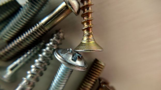 Screws bolts randomly lie close-up on the table. Macrophotography.Texture or background.Selective focus.