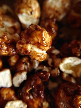 Sweet food a handful of brown popcorn with caramel close-up.Macro photography.Texture or background.Selective focus.