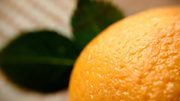 Top view of an orange with green leaves leaves close-up.Macro photography.Texture or background.Selective focus.