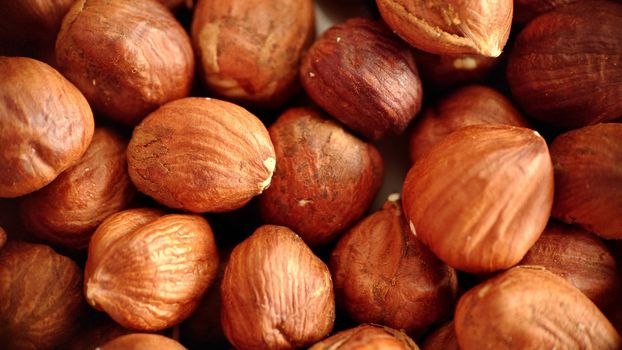 A handful of large hazelnuts in close-up, selective focus.Macrophotography.Texture or background. Selective focus.