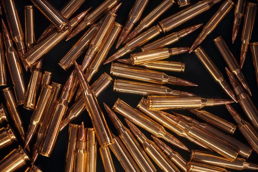 Ammonution on dark table. Ammo pile, war ammo background. Rounds and military technology. Guns and Ammo background. Production of ammunition at the factory. Bullet ammunition manufacturing process