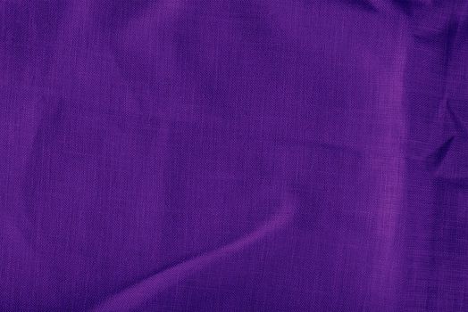 Purple linen fabric. Texture of crumpled linen fabric in folds close-up